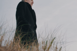 Poet Paul Farley. Dressed in black on a cold dune. Staring out to sea.