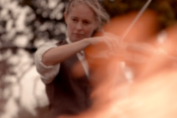 A violinist seen through fire