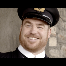 close up of a vintage station master smiling