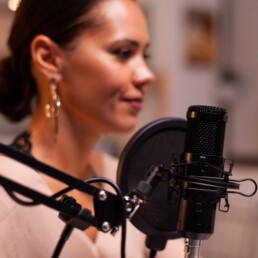 a woman recording a podcast at the Sound and Bones studio.